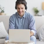 man-in-earphones-using-laptop-listening-to-podcast-5DEU3VT.jpg